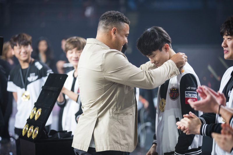 Imagem do ronaldo entregando a medalha de campeão do MSI 2017 para Faker, da SKt T1