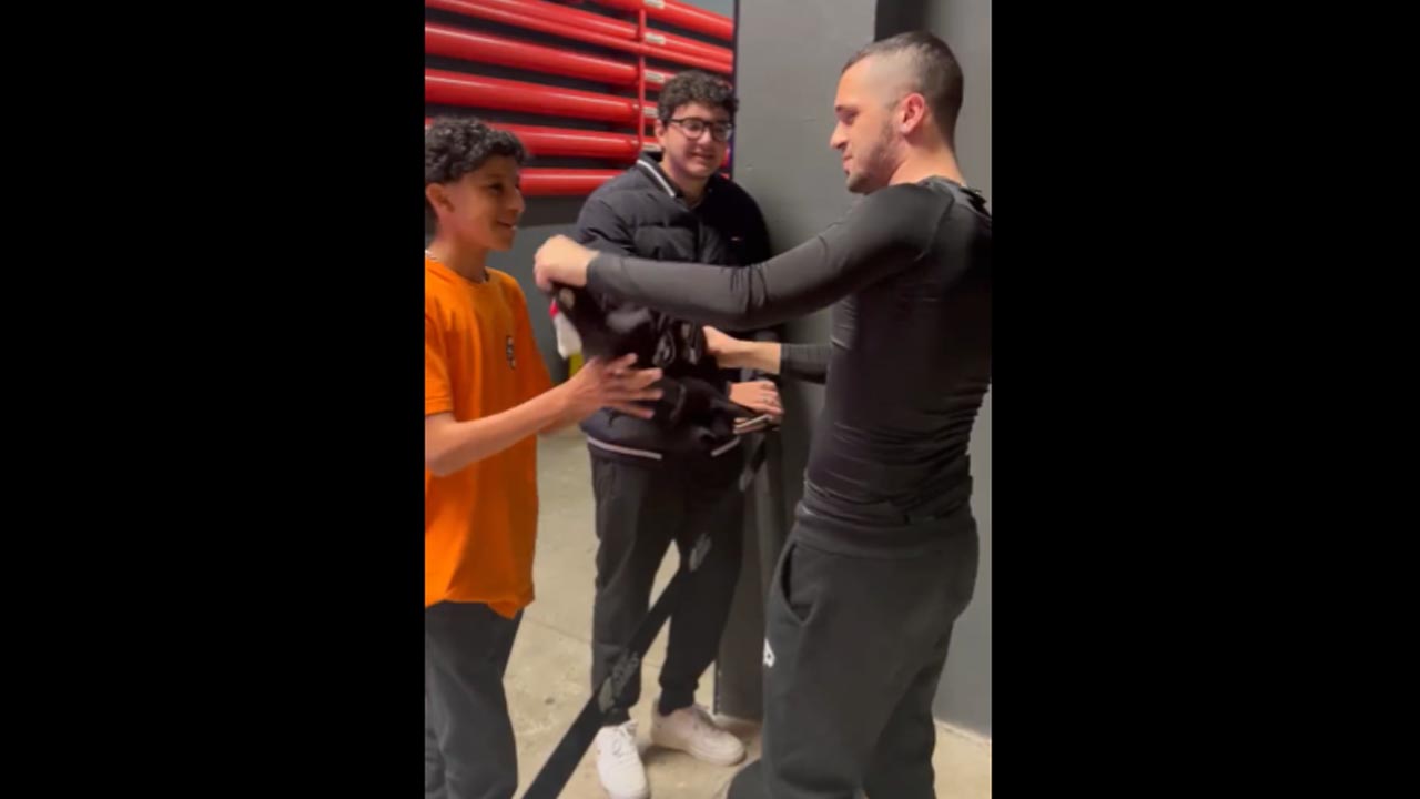 Imagem do jogador Dynquedo presenteando um fã com seu uniforme