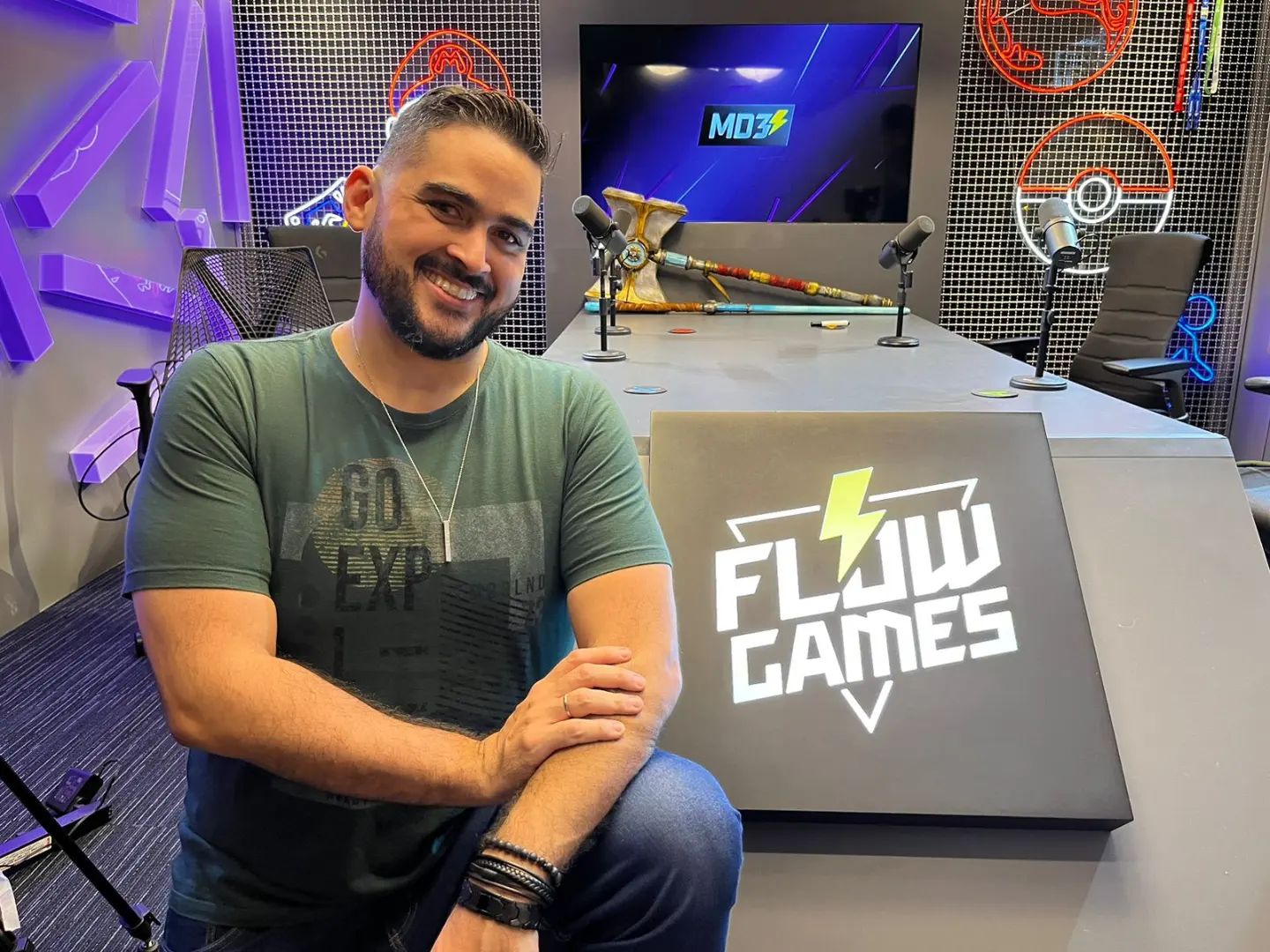 Schaeppi na frente de uma placa do Flow Games, dona do MD3 Podcast
