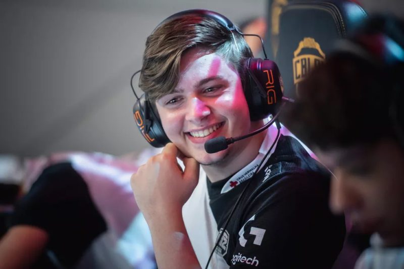 Hauz sorrindo sentado na cadeira do CBLOL