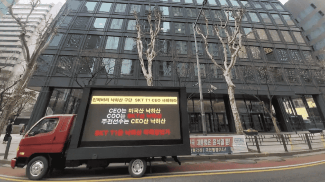 Foto do protesto de torcedores da T1 em caminhão em frente a sede da equipe;